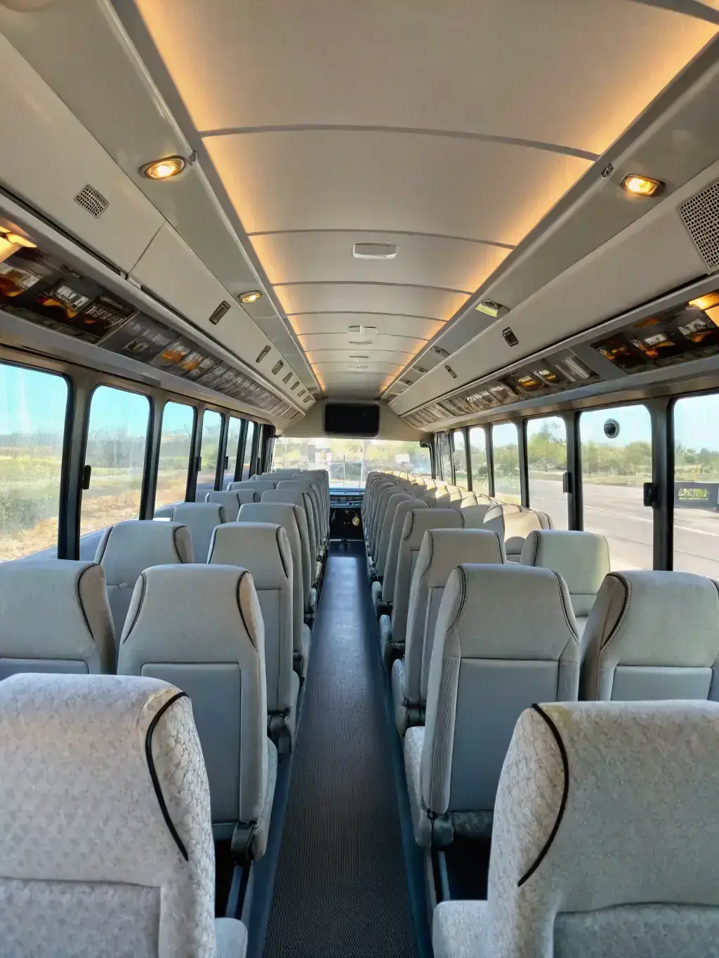 An interior shot of a luxury minibus, showcasing comfortable seating, individual reading lights, and ample legroom. The image should convey the feeling of a private, upscale travel experience for larger groups.